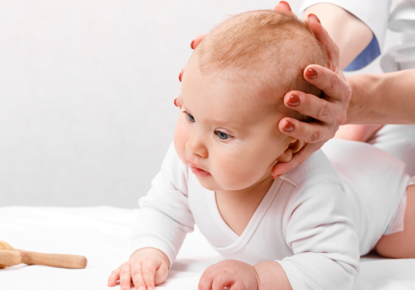 baby getting head examined by osteopath